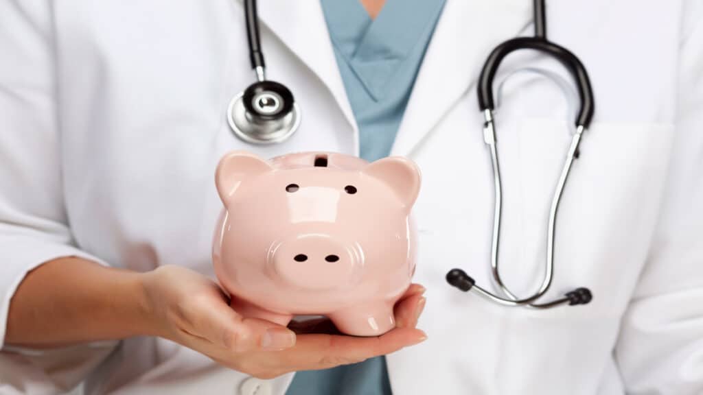 doctor holding piggy bank