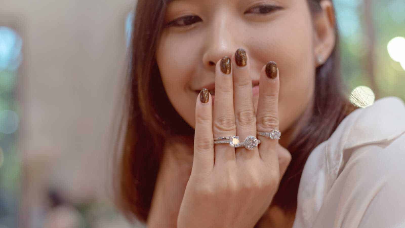 Woman Wearing Many Different Elegant Engagement Diamond Ring in Beautiful Girl Finger.