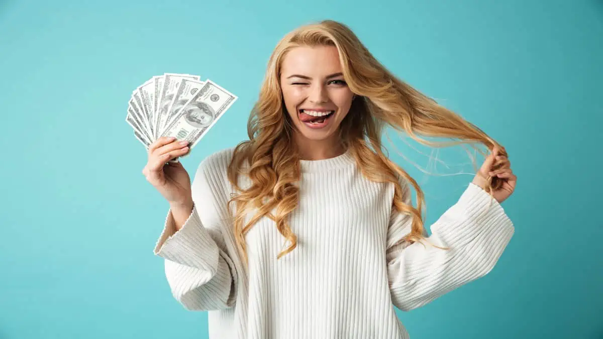 blonde woman holding money winking