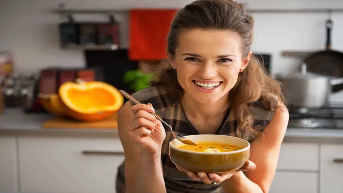 woman smiling eating soup