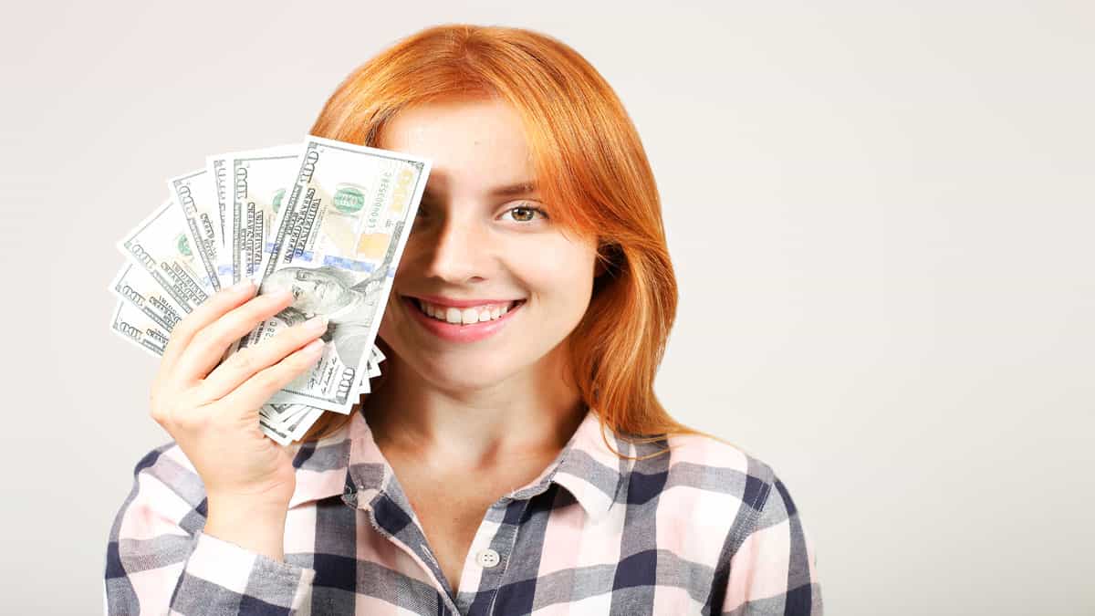 woman covering part of face with money