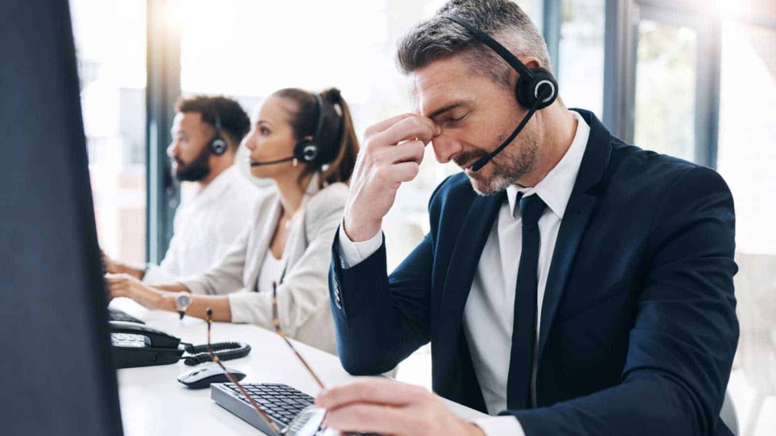 Man with headphones stressed at work