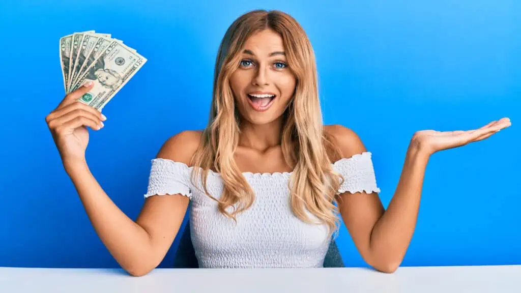 blonde woman holding cash