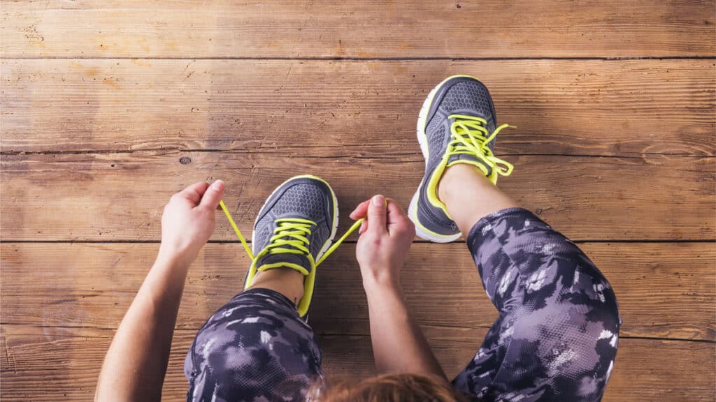 woman putting on sneakers