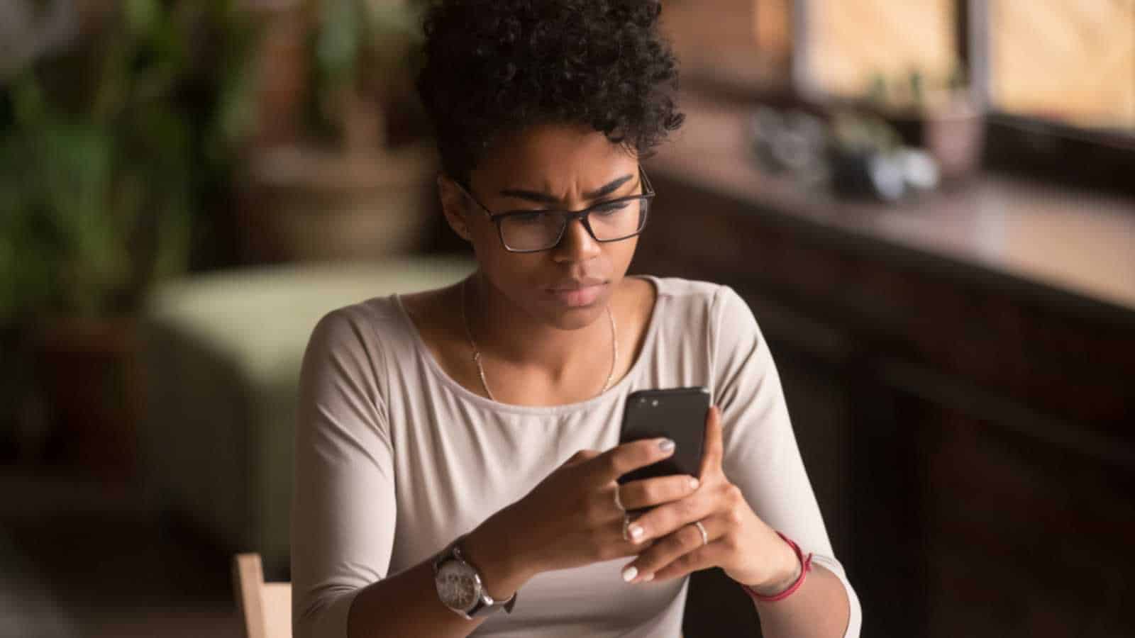 Woman looking at phone stressed