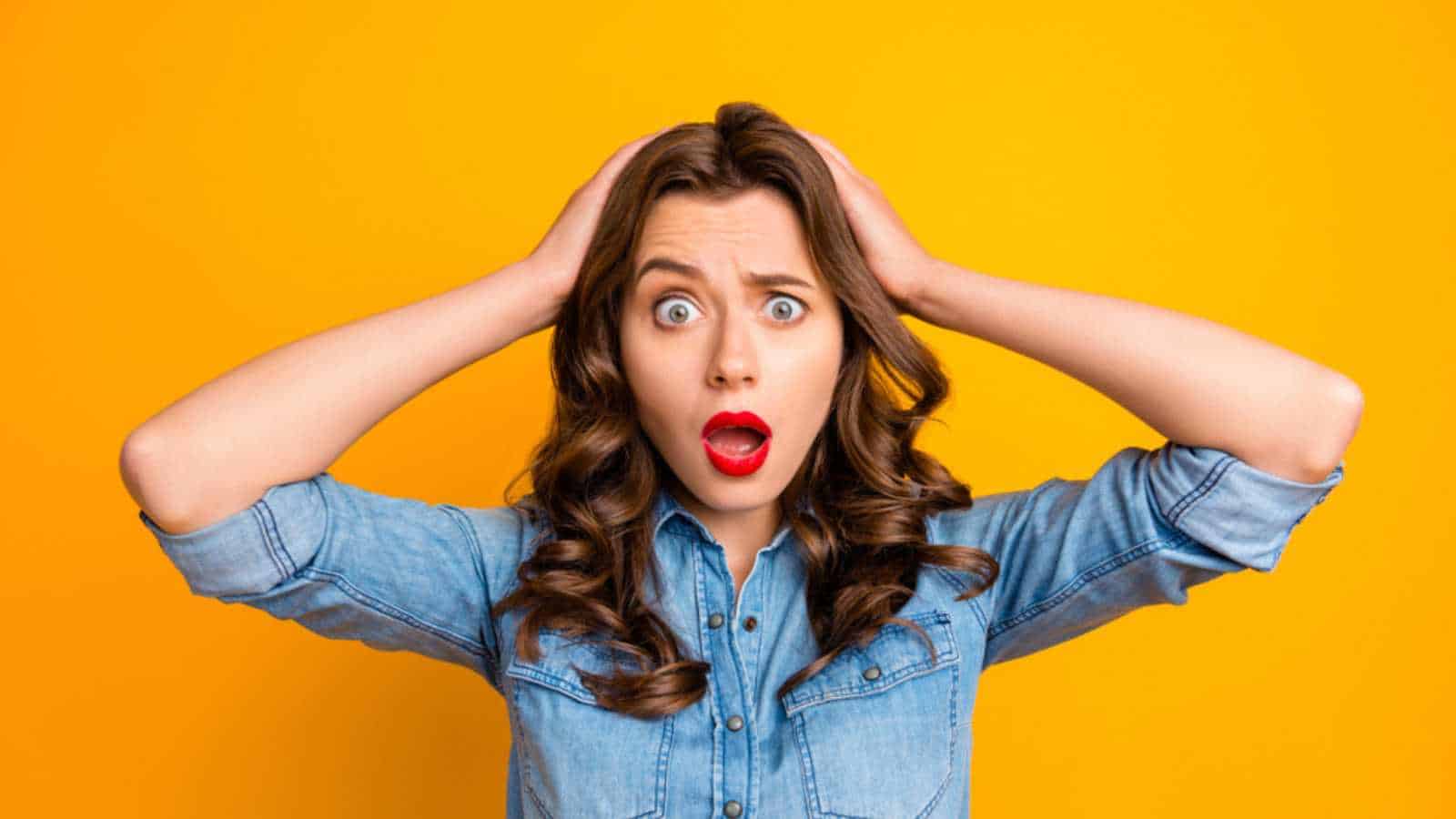 Woman shocked with hands on head