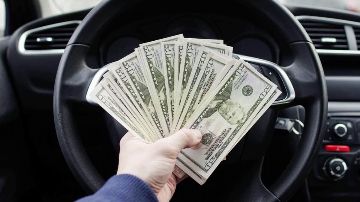 man-holding-money-in-car