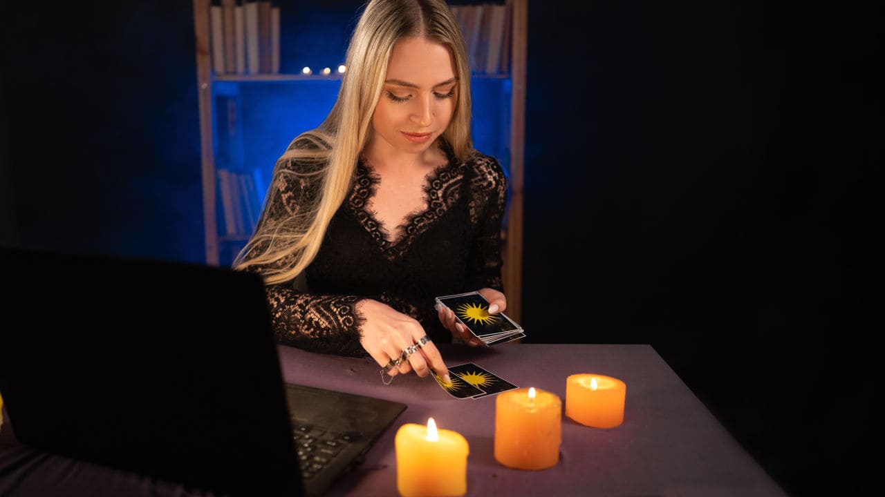The fortune teller or Psychic with Laptop Computer, Online astrology. Reading tarot cards.