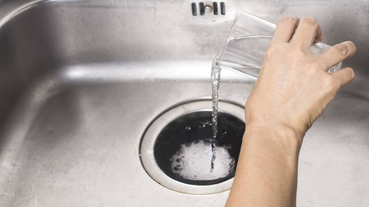 pouring vinegar and liquid down drain