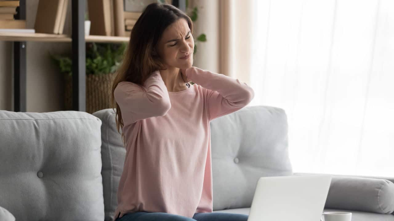 woman stressed and neck hurting while on computer