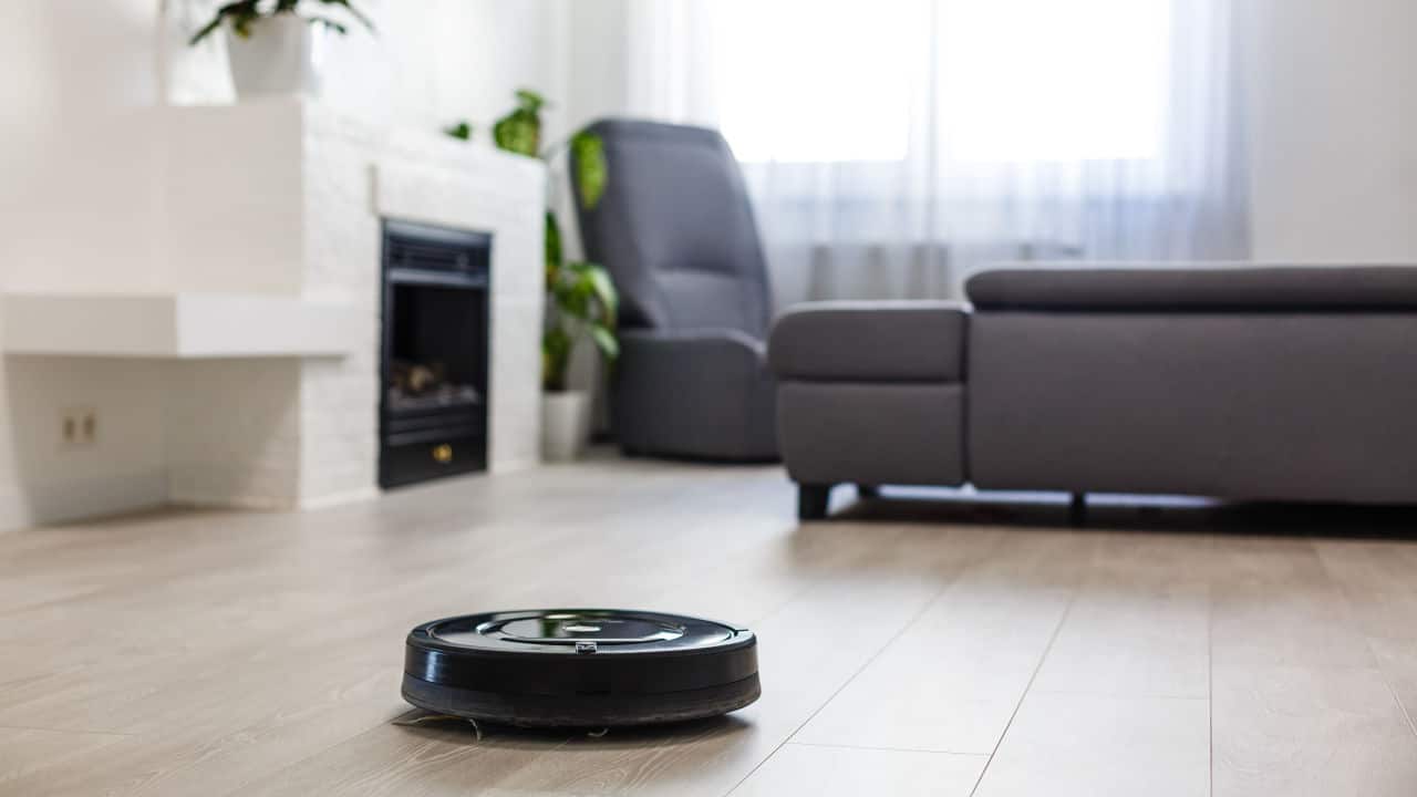 Robotic vacuum cleaner on laminate wood floor in living room