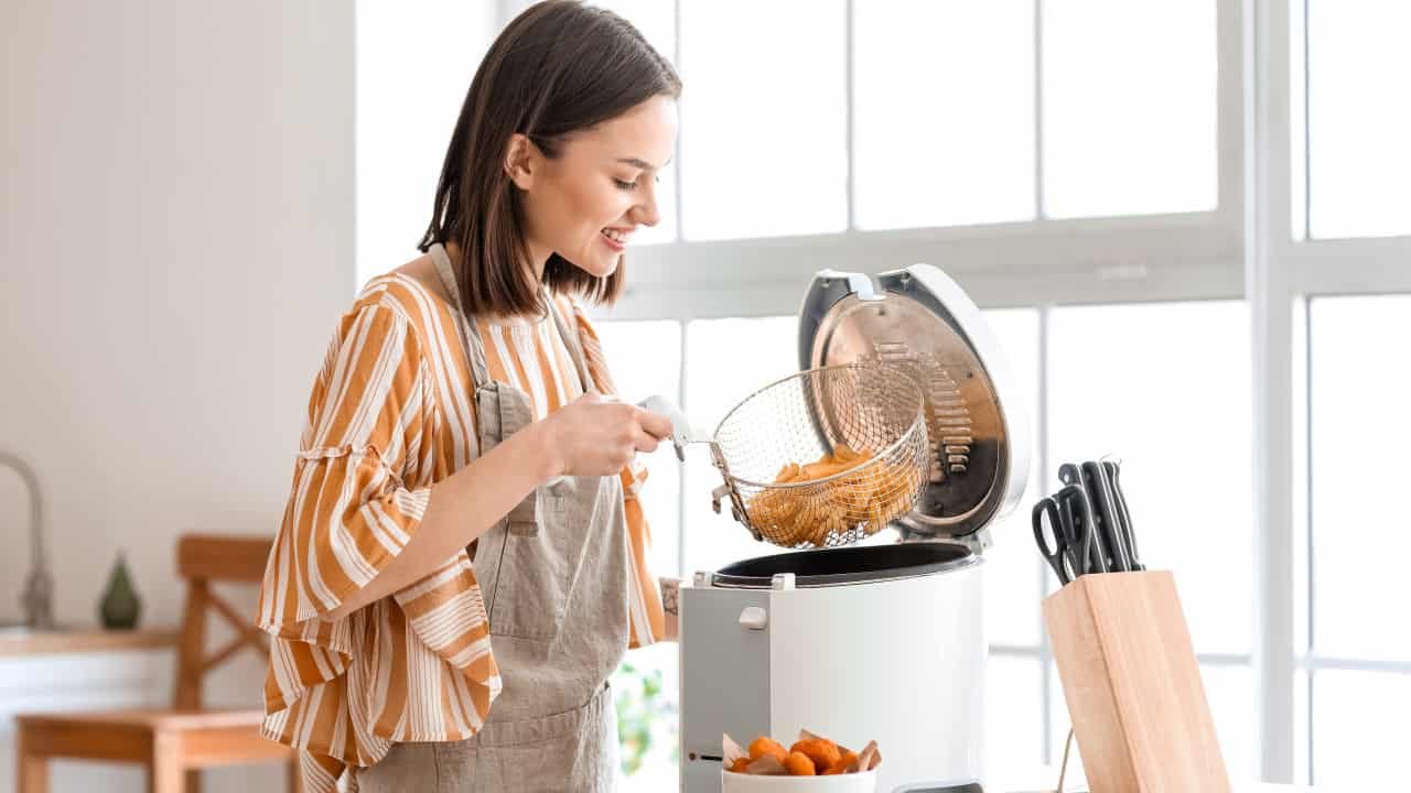 woman in the kitchen using a deep fryer