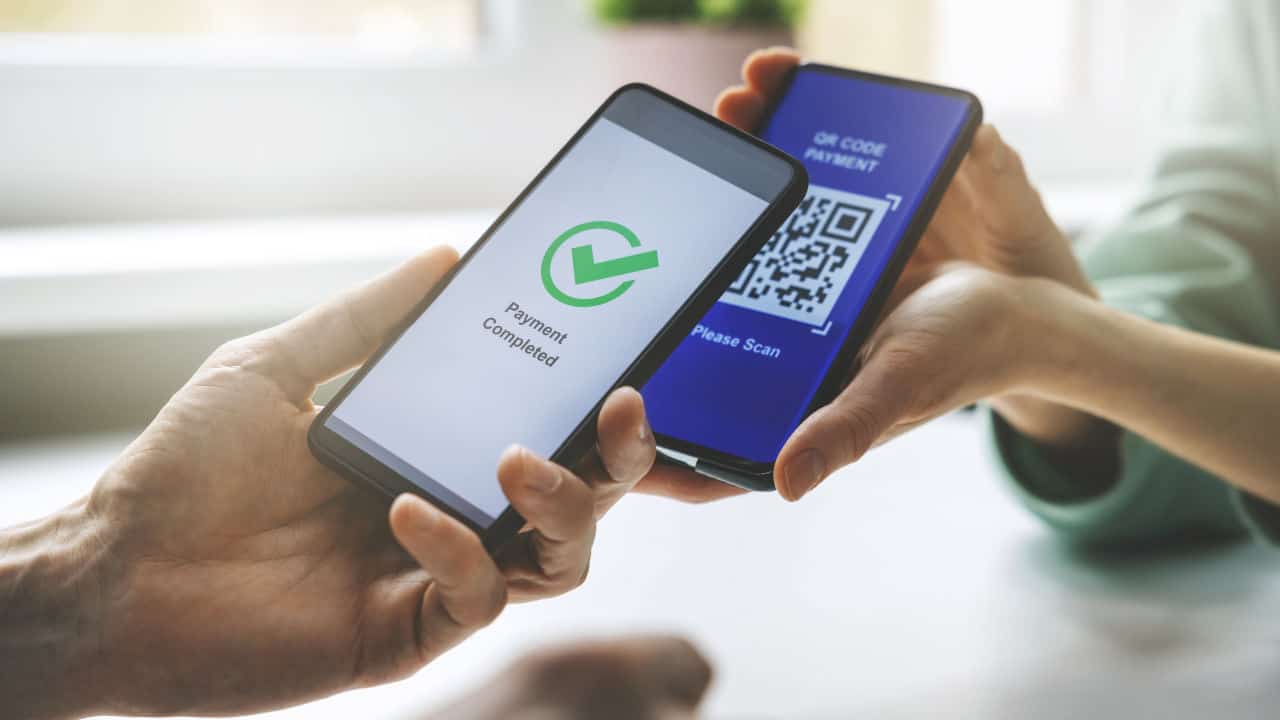 qr code payment - person paying with mobile phone