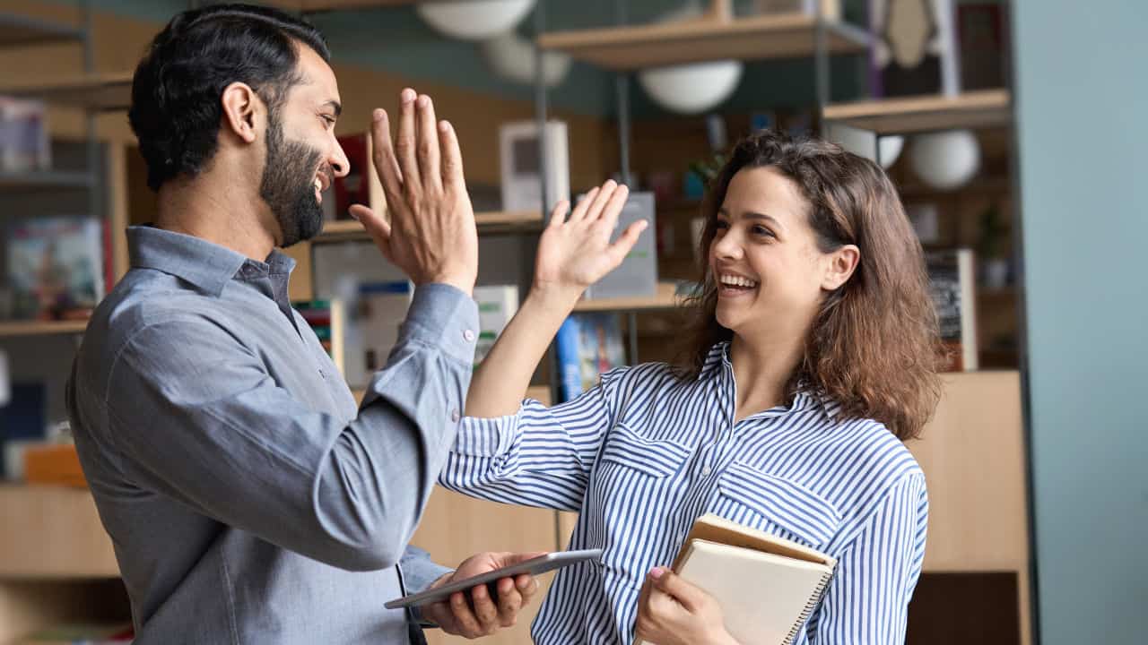 two people giving each other a high five at work