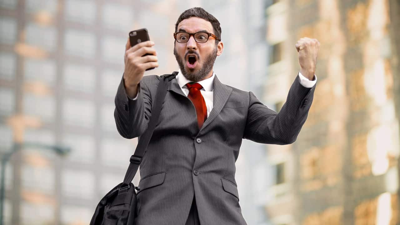 happy executive sales businessman cheering excited in celebration after good news
