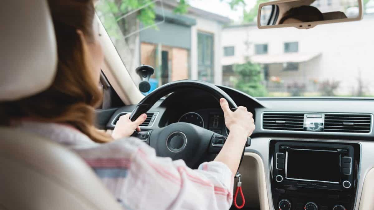 Partial view of woman driving car alone