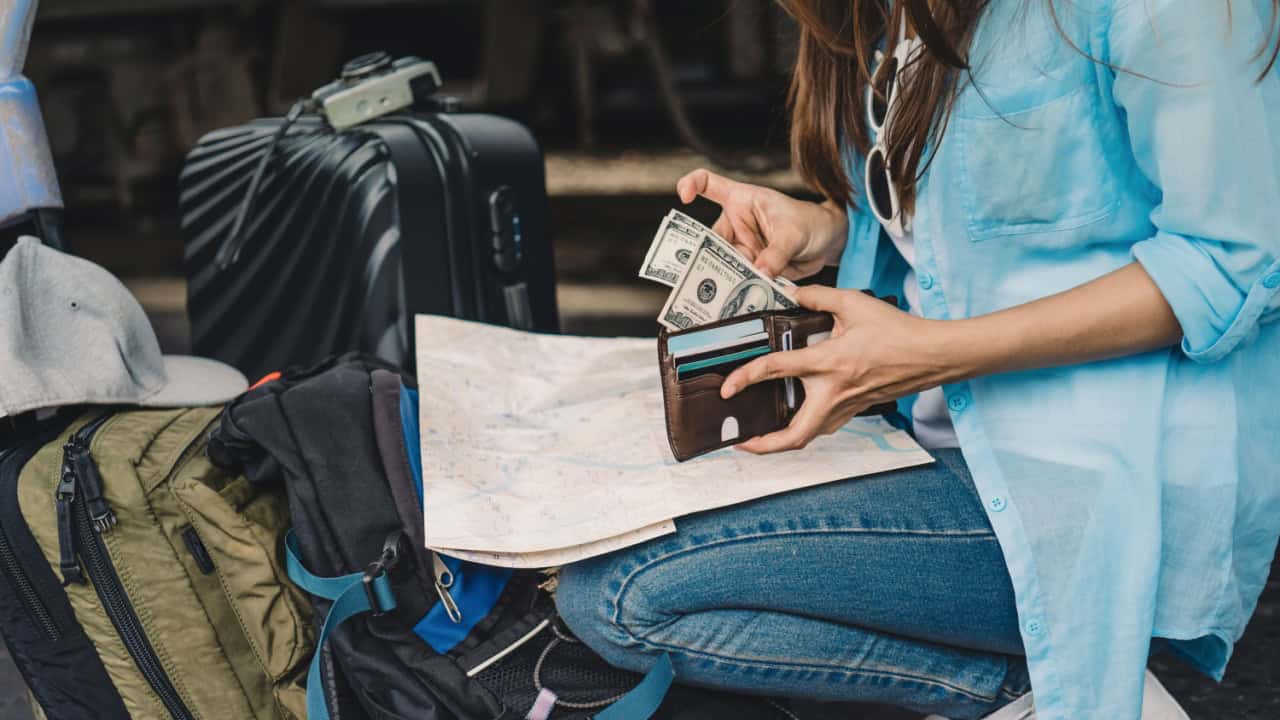 girl with backpack Counting US dollars money in wallet
