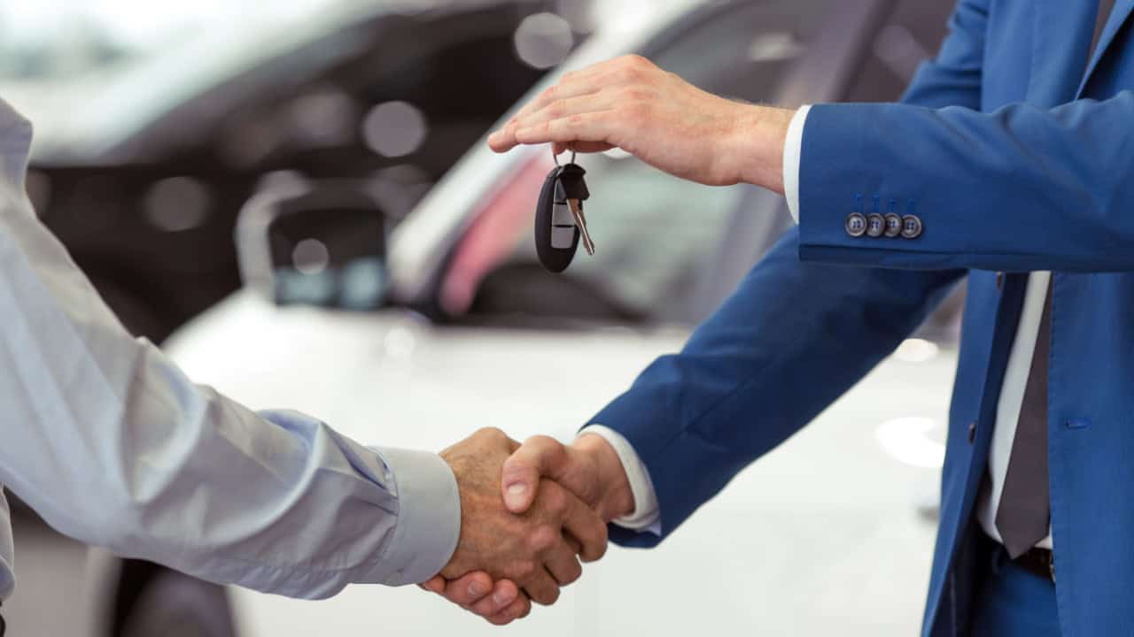 Handshake of two businessmen when selling a car