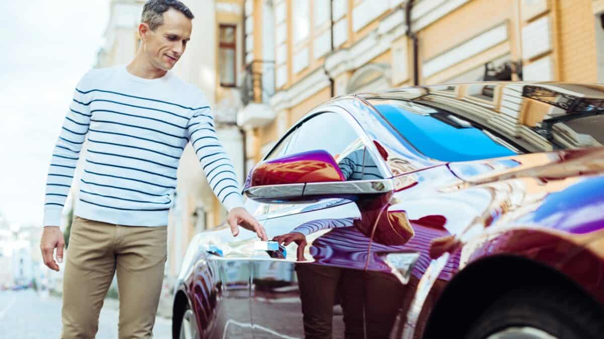 Positive pleasant man opening his car