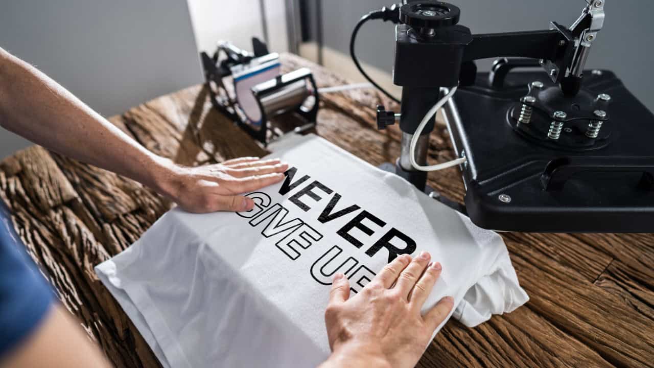Man Printing On T Shirt In Workshop