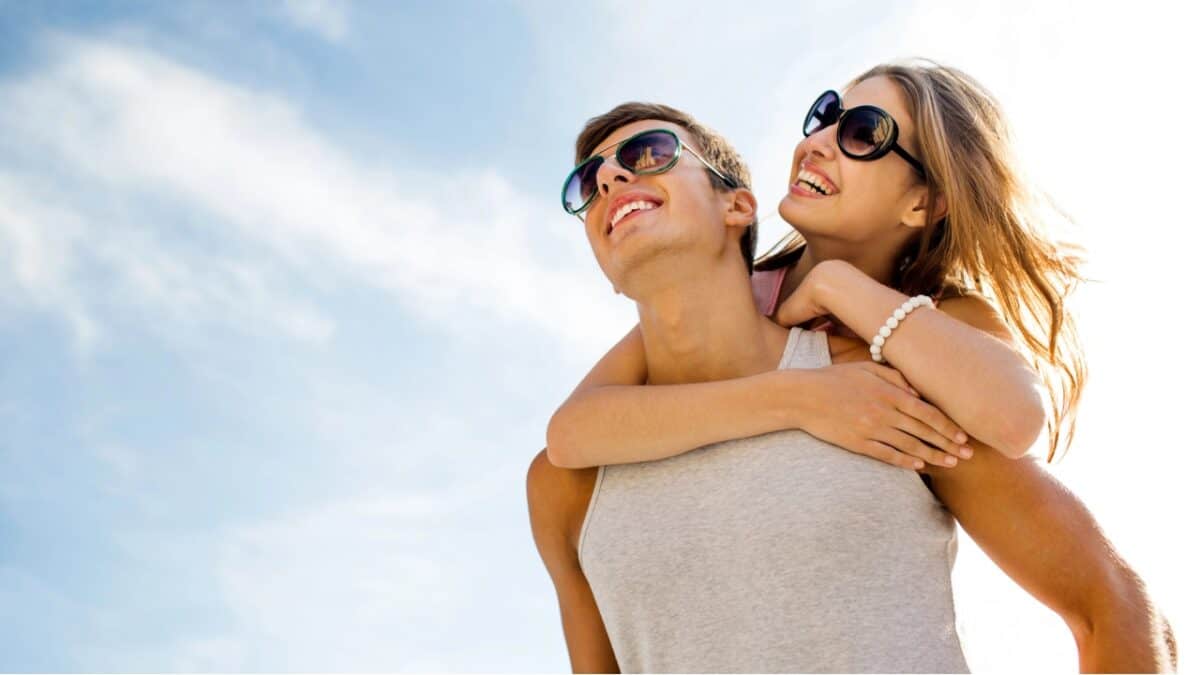 Smiling couple having fun over sky background